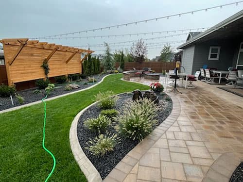 Paver walkway winding through a landscaped Treasure Valley yard