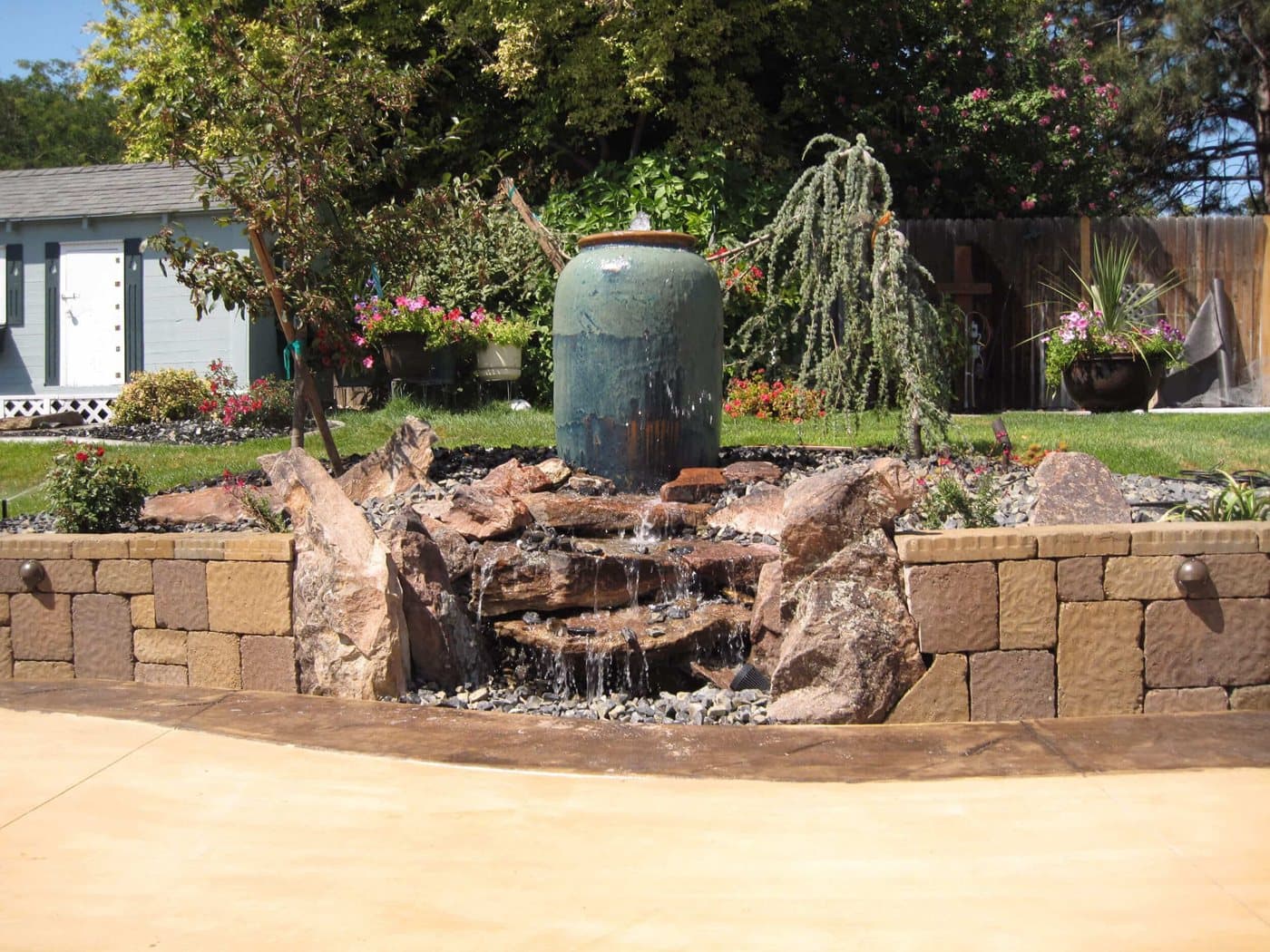 Custom backyard water feature with natural stone surround